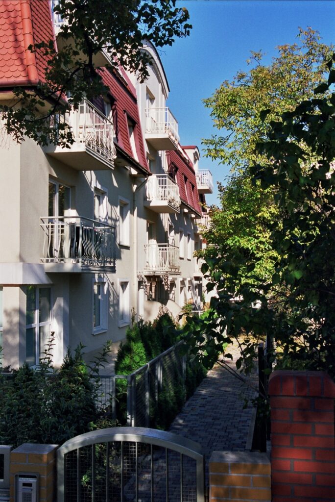 Widok na budynek przy ulicy Boya-Żeleńskiego od strony furtki wejściowej. Ścieżka prowadząca do budynku ukryta wśród drzew