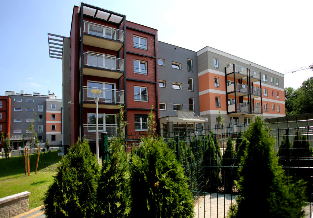 Ukończony blok mieszkalny z unikatową fasadą będącą połączeniem cegły oraz elewacji w odcieniach szarym i pomarańczowym