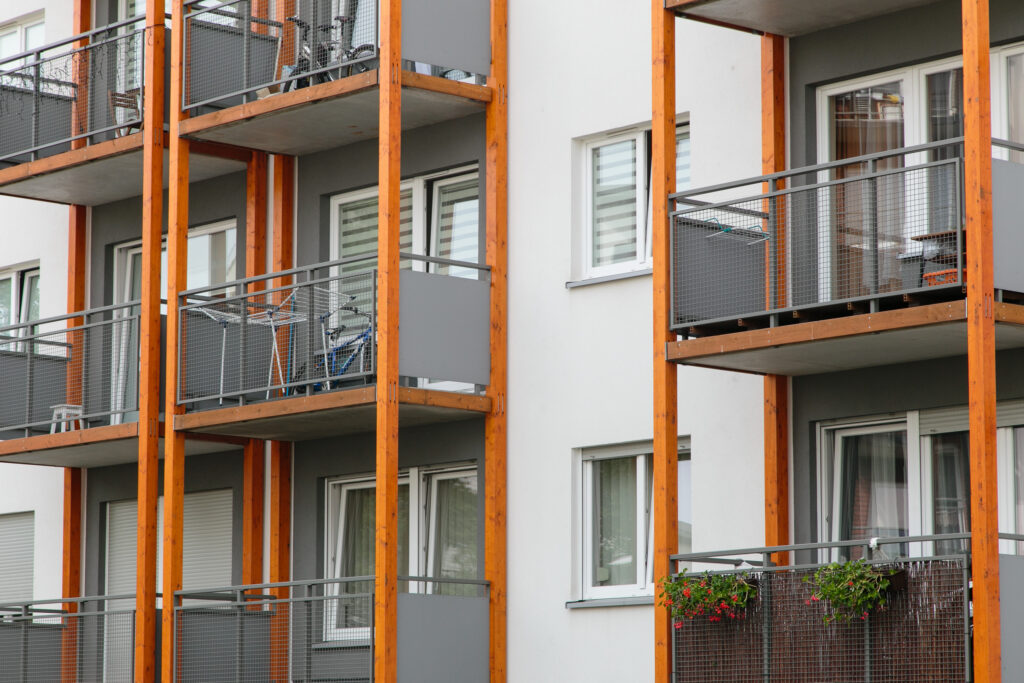 Zbliżenie na balkony budynku mieszkalnego w Olimpi Port. Balkony ozdobione drewnianymi belkami