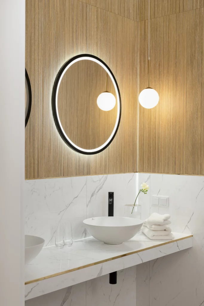 Powtarzający się motyw koła w projekcie łazienki jest multiplikowany w innych częściach domu co zapewnia całemu apartamentowi spójność.